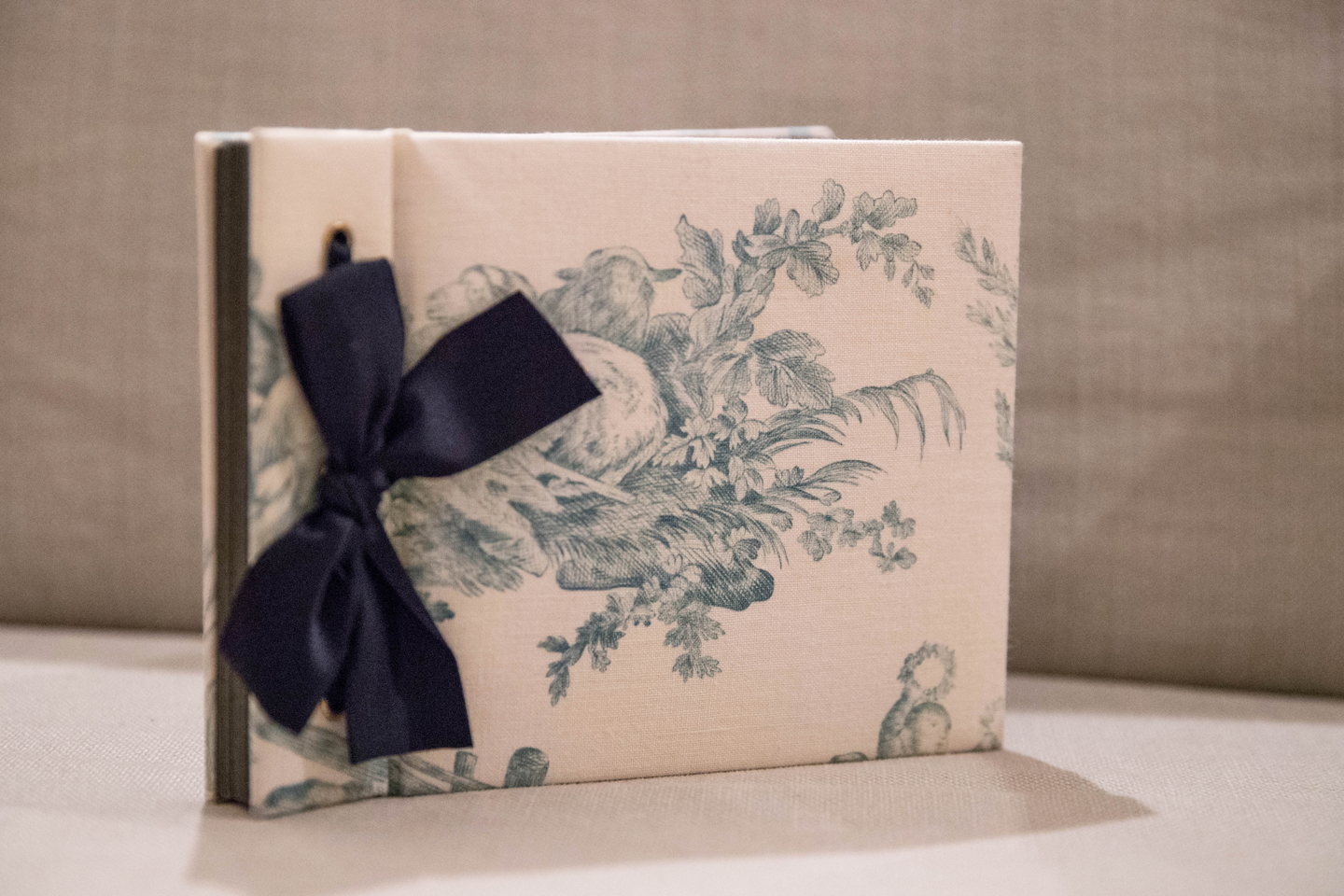 永岡さんがアルバム本体から自作したもの。中綿が入った布張り表紙に濃紺のリボンがシックなイメージです。コラージュした写真はシンプルに構成しつつ、ラインストーンをあしらうなどさりげなく手が込んでいます。