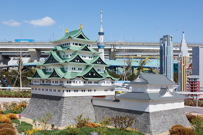 レゴ®ブロックで作った名古屋城と東京スカイツリー、そしてその背後に本物の高速道路の橋がある風景が見られる